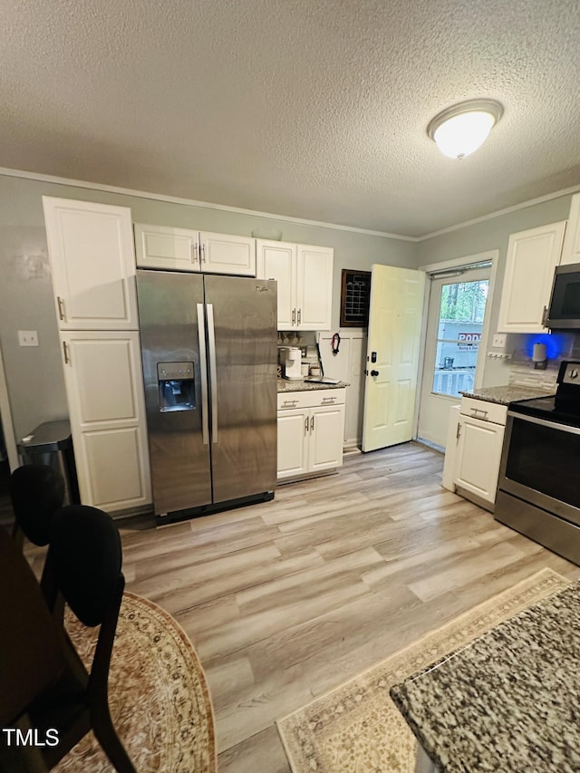 kitchen featuring stainless steel appliances, a textured ceiling, white cabinets, light wood-style floors, and crown molding