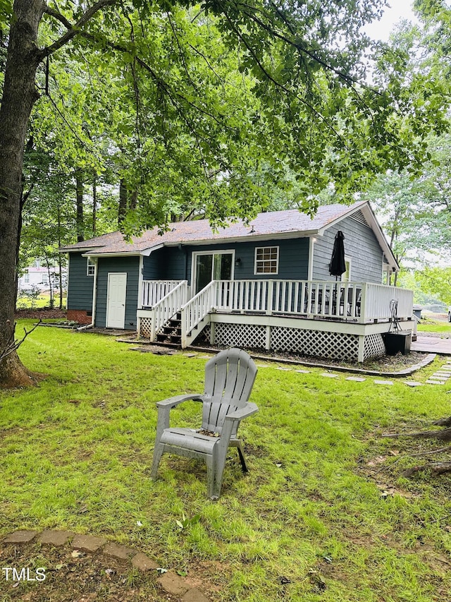 back of house featuring a wooden deck and a lawn