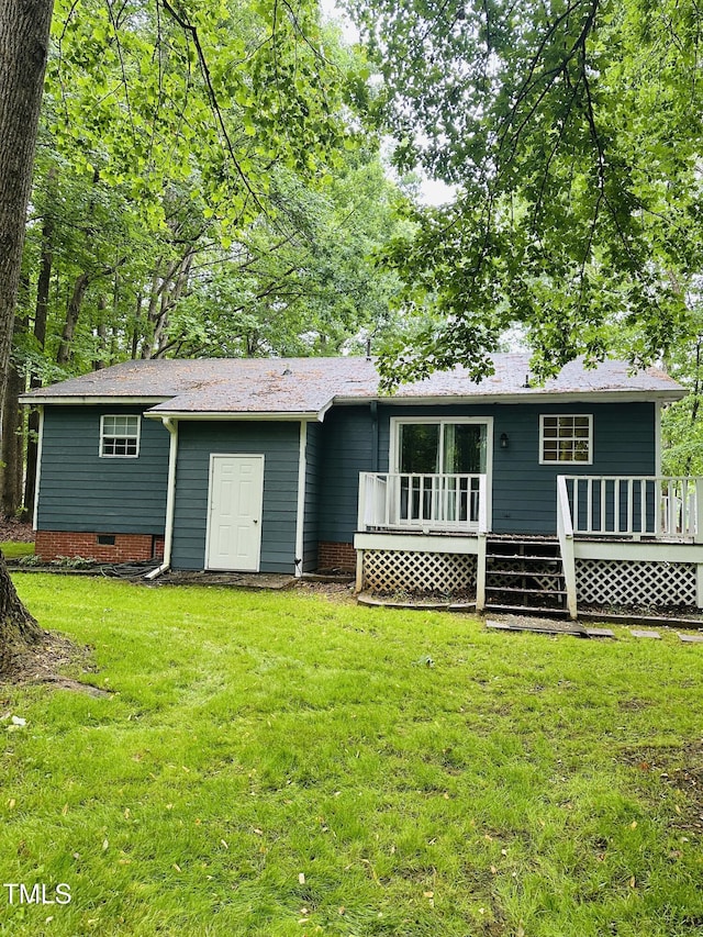 back of house featuring a deck and a yard