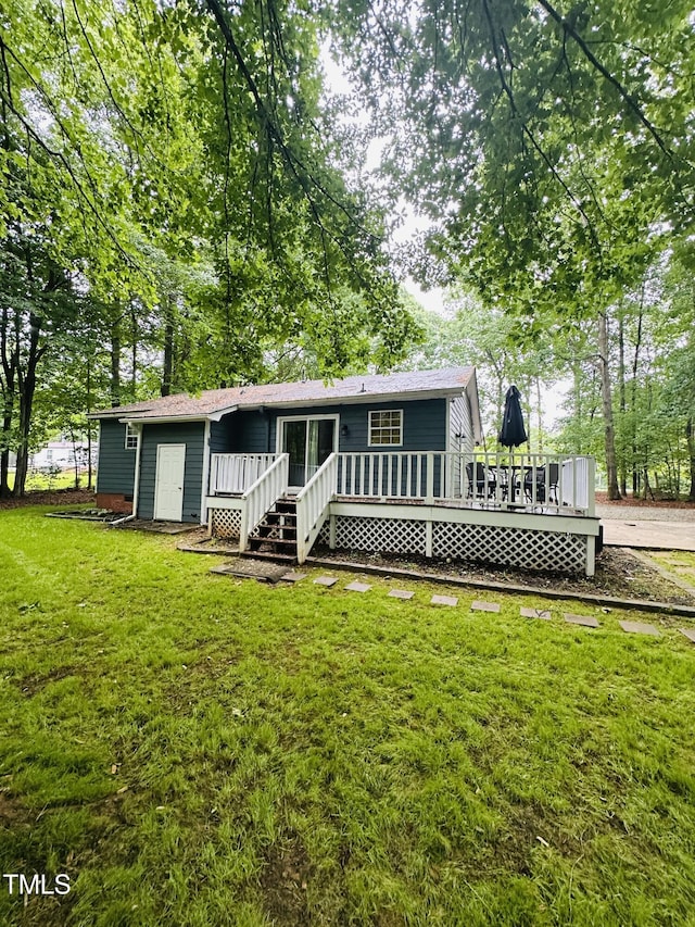 rear view of house featuring a deck and a yard