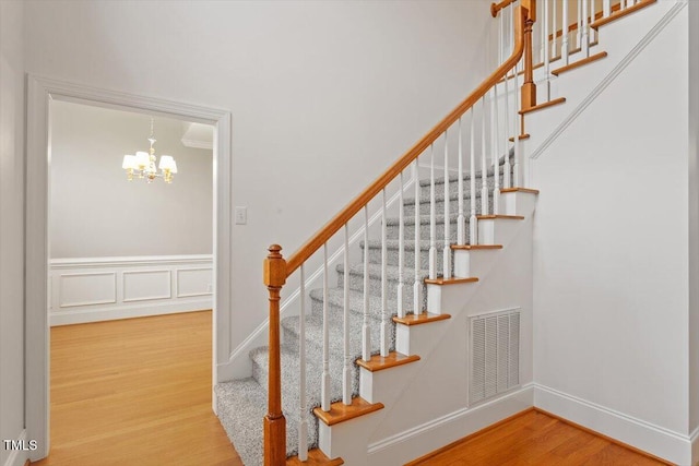 6335 Cedar Waters Dr, Raleigh, NC 27607 - staircase with wood finished floors, a chandelier, and baseboards
