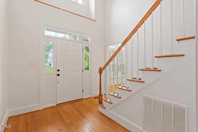 6335 Cedar Waters Dr, Raleigh, NC 27607 - foyer entrance featuring stairway, baseboards, wood finished floors, and a towering ceiling
