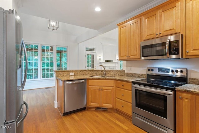 6335 Cedar Waters Dr, Raleigh, NC 27607 - kitchen with stainless steel appliances, a sink, a peninsula, light wood-style flooring, and light stone countertops