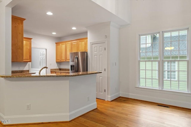 6335 Cedar Waters Dr, Raleigh, NC 27607 - kitchen with stainless steel refrigerator with ice dispenser, plenty of natural light, baseboards, light wood finished floors, and ornamental molding