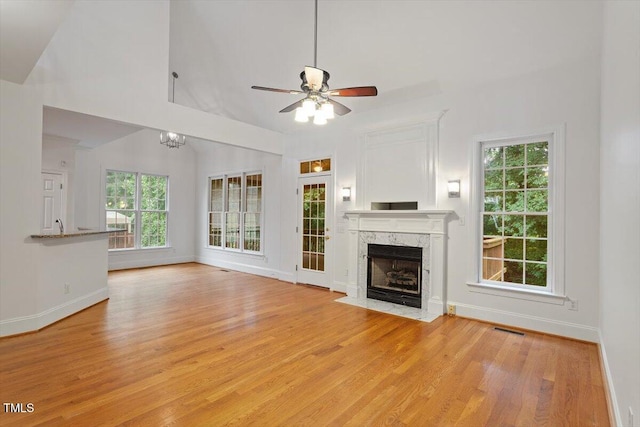 6335 Cedar Waters Dr, Raleigh, NC 27607 - unfurnished living room featuring baseboards, light wood finished floors, ceiling fan, healthy amount of natural light, and a high ceiling