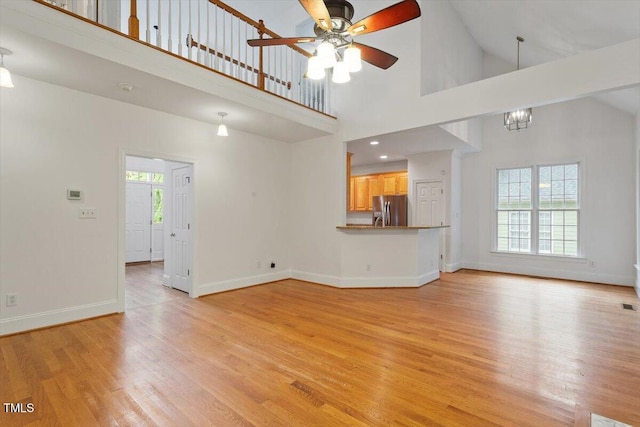 6335 Cedar Waters Dr, Raleigh, NC 27607 - unfurnished living room with healthy amount of natural light, ceiling fan, light wood-style floors, high vaulted ceiling, and baseboards