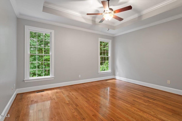 6335 Cedar Waters Dr, Raleigh, NC 27607 - empty room with hardwood / wood-style floors, healthy amount of natural light, a raised ceiling, baseboards, and crown molding