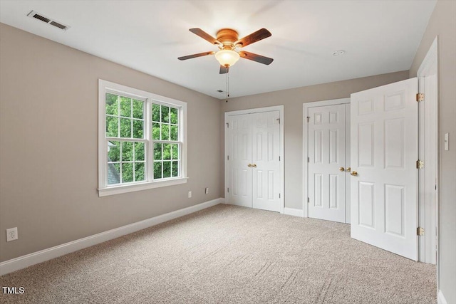 6335 Cedar Waters Dr, Raleigh, NC 27607 - unfurnished bedroom featuring two closets, carpet flooring, baseboards, and ceiling fan