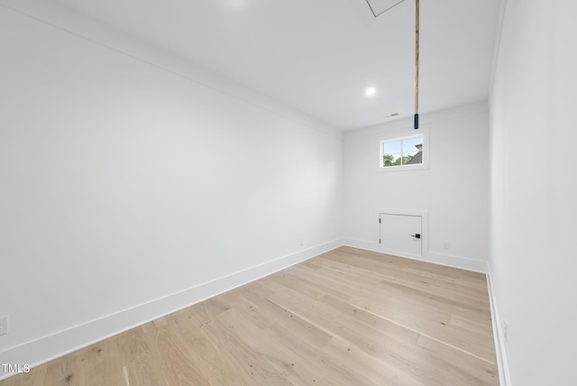 clothes washing area with baseboards, light wood-style floors, and attic access