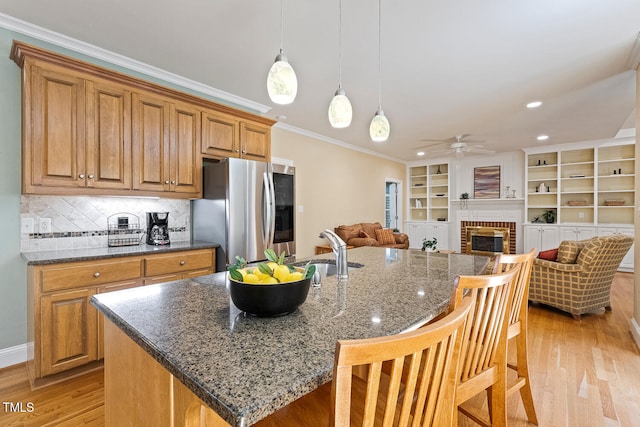 105 Windfall Ct, Cary, NC 27518 - kitchen featuring smart refrigerator, ceiling fan, light wood-style flooring, a fireplace, and crown molding