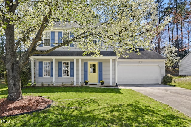 view of front of home featuring an attached garage, driveway, a front lawn, and covered porch