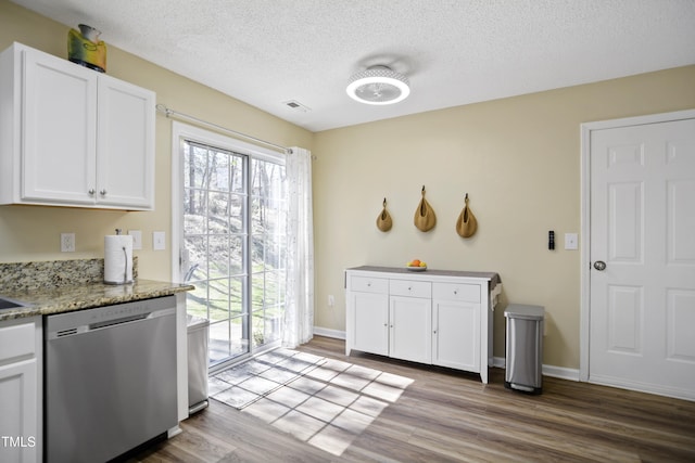 kitchen with dishwasher, white cabinets, wood finished floors, a textured ceiling, and light stone countertops