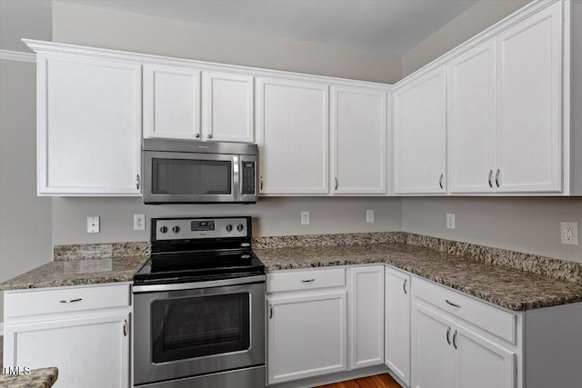 kitchen with appliances with stainless steel finishes, white cabinets, and stone counters