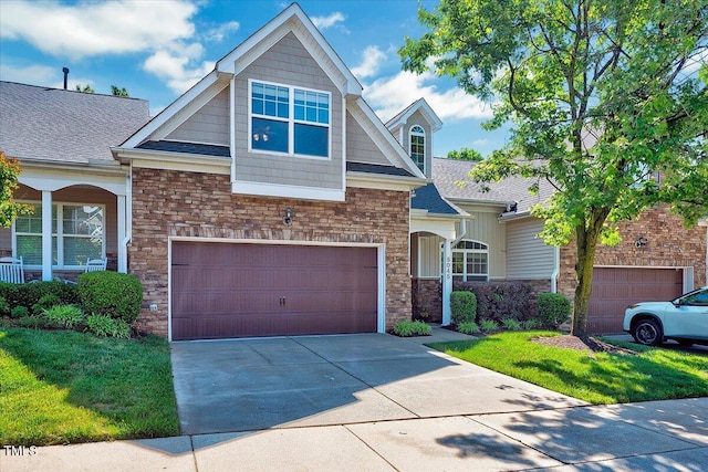 view of front facade with driveway, a front lawn, stone siding, and a garage