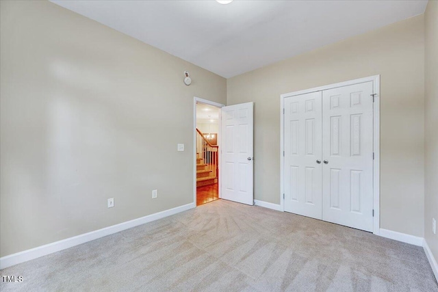 unfurnished bedroom with carpet floors, baseboards, and a closet