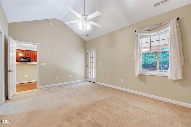empty room featuring a ceiling fan, light carpet, baseboards, and high vaulted ceiling