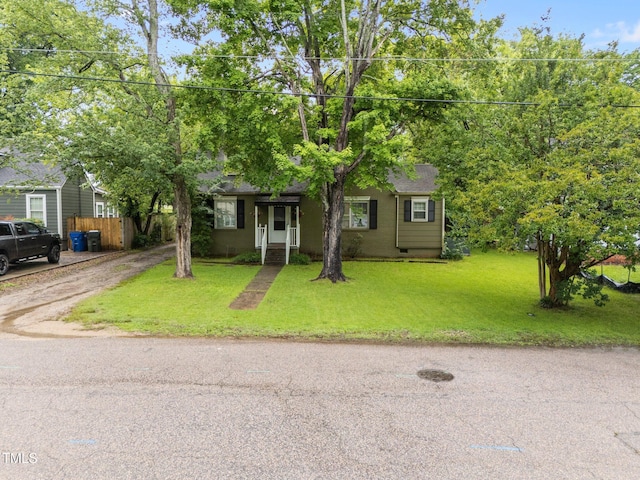 view of property hidden behind natural elements featuring driveway and a shingled roof