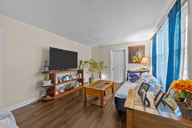living area featuring a textured ceiling, wood finished floors, and baseboards