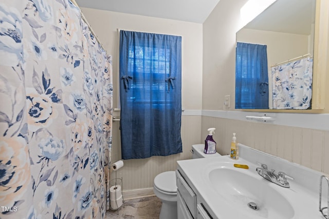 full bath with toilet, vanity, a shower with curtain, and wainscoting