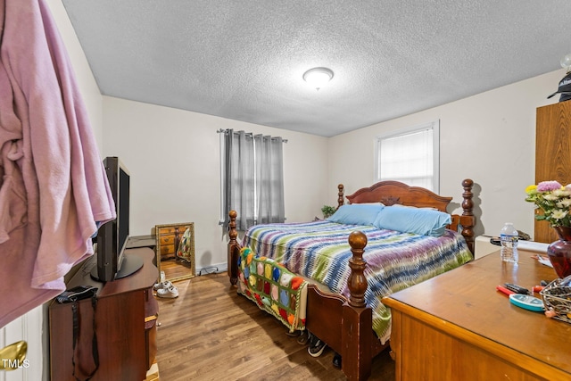 bedroom with light wood-style floors and a textured ceiling