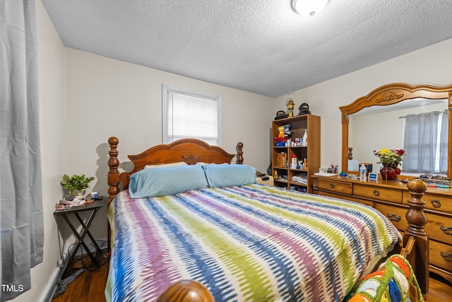 bedroom with wood finished floors and a textured ceiling