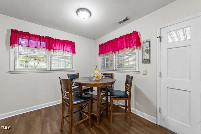 dining area with baseboards and wood finished floors