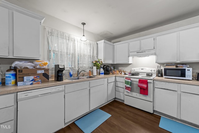 kitchen featuring white appliances, a sink, under cabinet range hood, and light countertops