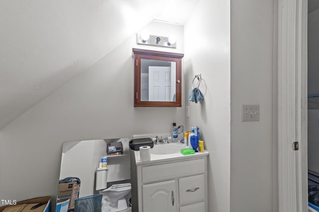 half bathroom with vaulted ceiling, vanity, and toilet