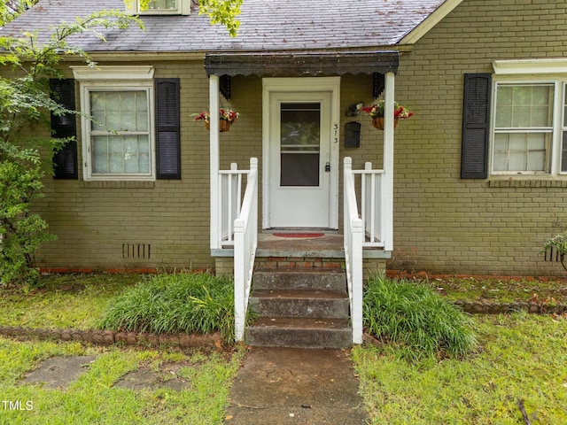 doorway to property with brick siding and crawl space