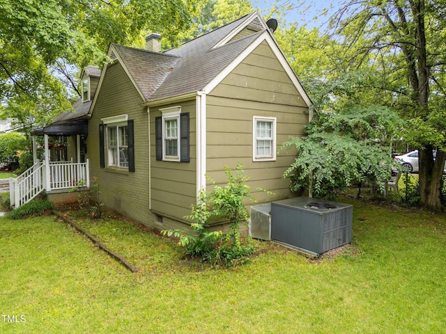 view of home's exterior with a chimney, a lawn, roof with shingles, and crawl space