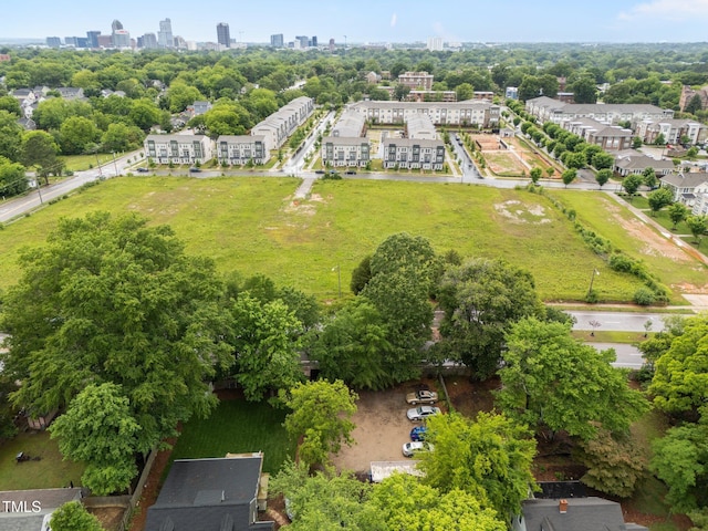 aerial view of property's location featuring nearby urban area and a tree filled landscape
