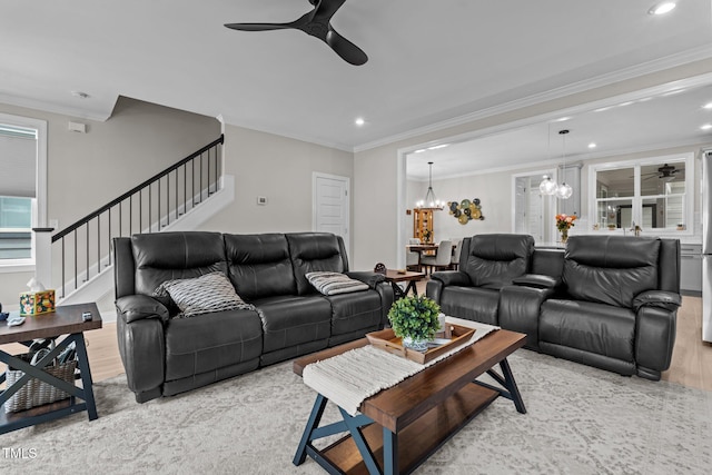 living room featuring a ceiling fan, stairway, ornamental molding, a chandelier, and recessed lighting