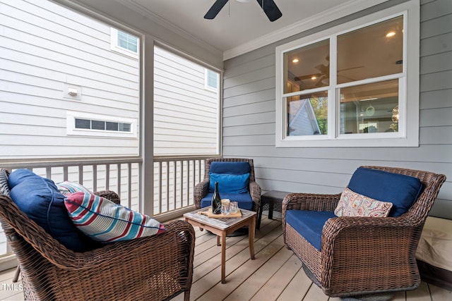 wooden terrace with a ceiling fan and an outdoor living space