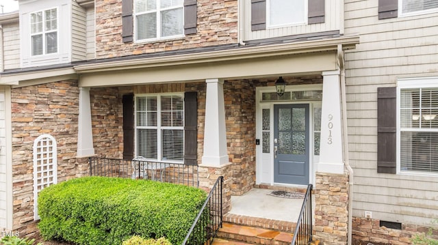 doorway to property featuring stone siding and a porch