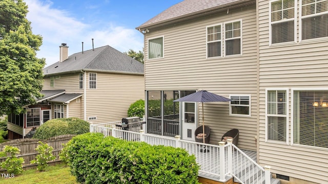 back of property with a sunroom and fence