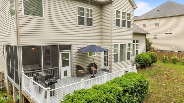 rear view of house featuring a deck and fence