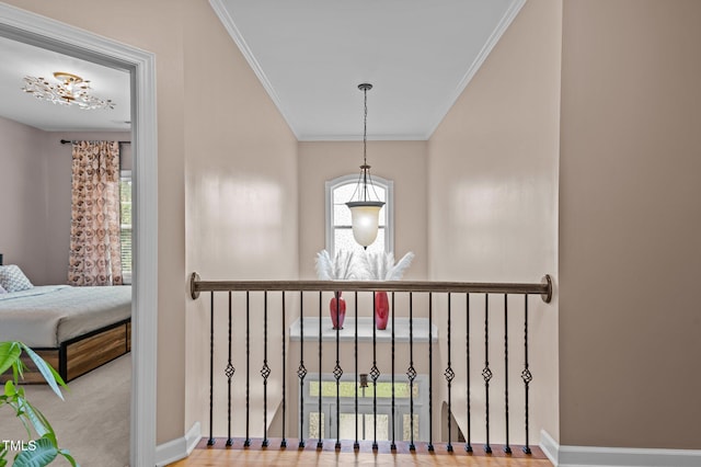 corridor with healthy amount of natural light, crown molding, and baseboards
