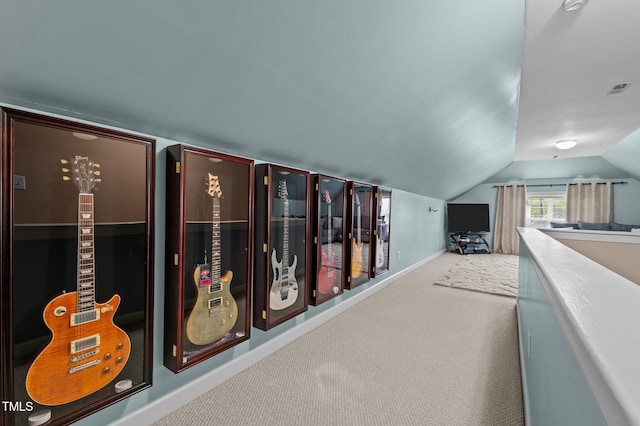 hall featuring carpet, lofted ceiling, and baseboards