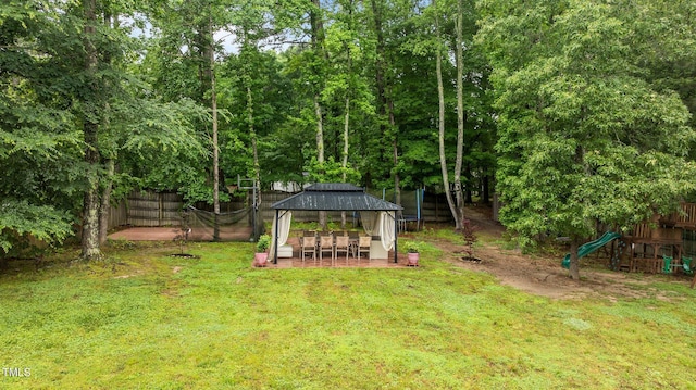 view of yard featuring a gazebo, a playground, and a patio area