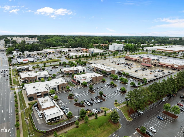 bird's eye view of a commercial area and a tree filled landscape