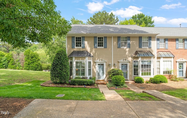 view of front of property with a front yard and roof with shingles