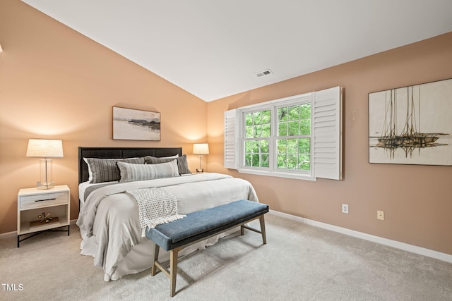 bedroom with baseboards, vaulted ceiling, and carpet