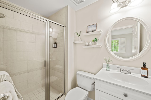bathroom featuring toilet, vanity, and a stall shower