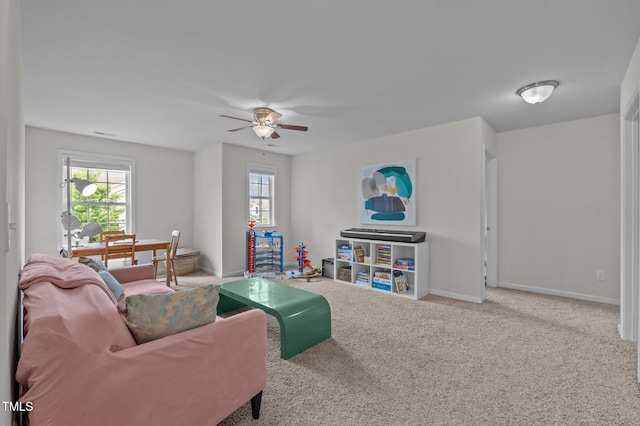 living room with healthy amount of natural light, ceiling fan, and baseboards