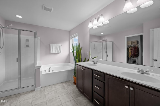 bathroom featuring a stall shower, a bath, double vanity, and a walk in closet