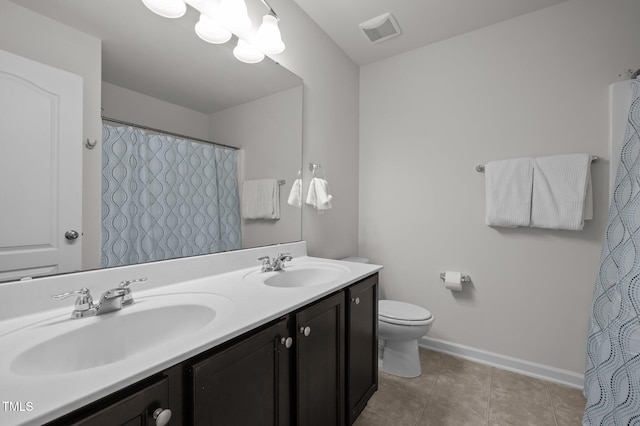 full bathroom with toilet, baseboards, double vanity, and tile patterned flooring