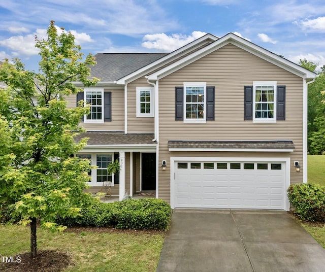 traditional home featuring concrete driveway, a garage, and a shingled roof