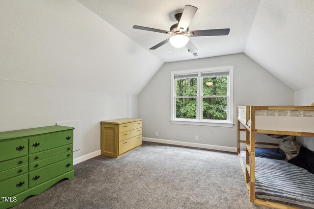 carpeted bedroom featuring vaulted ceiling, baseboards, and a ceiling fan