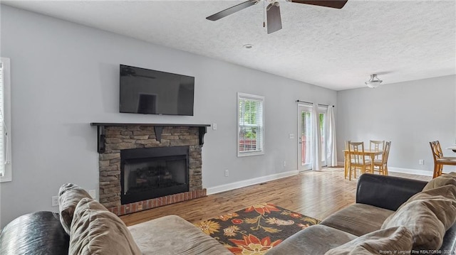 116 Argyll Ave, Aberdeen, NC 28315 - living area featuring wood finished floors, ceiling fan, a fireplace, baseboards, and a textured ceiling