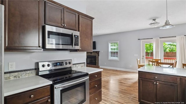 116 Argyll Ave, Aberdeen, NC 28315 - kitchen with appliances with stainless steel finishes, light countertops, baseboards, dark brown cabinetry, and light wood-type flooring